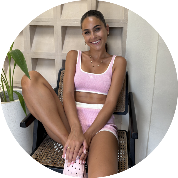 ines souriante assise sur en chaise ensemble rose